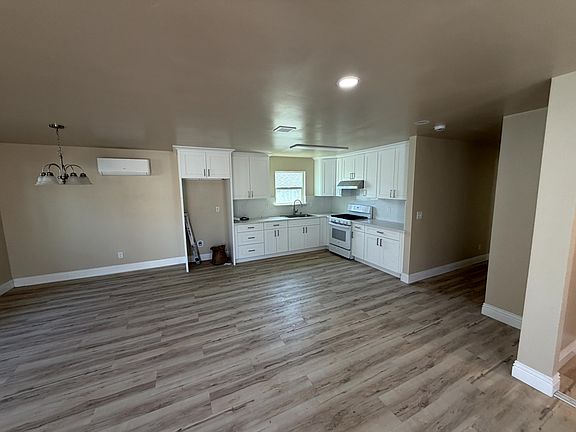 Open kitchen and dining area with white cabinetry and wood-look flooring.