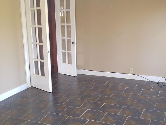 4 season family room with tile floors and wall of windows overlooking woods.