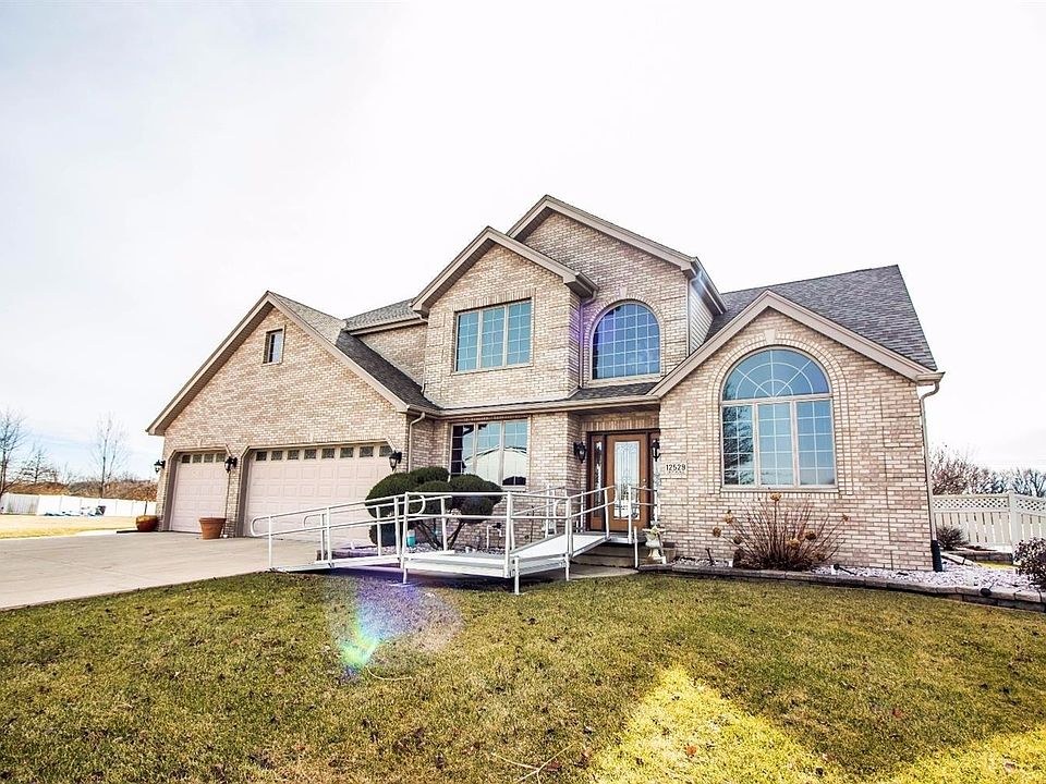 FRONT EXTERIOR OF UPSCALE 1 1/2 STORY CAPE COD STYLE HOME W/FULL FRONT BRICK, 3 CAR GARAGE, & UPGRADED FRONT DOOR!