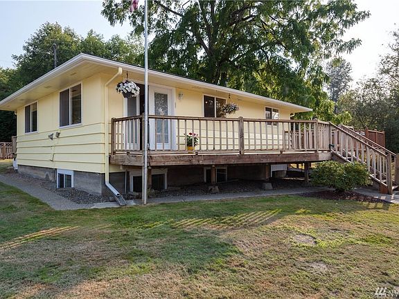 The back of the home has a custom-built deck, including a hot tub on the far end.