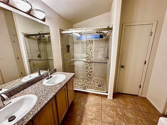 Updated beautiful bathroom with custom shower double sinks, granite countertops and linen closet.