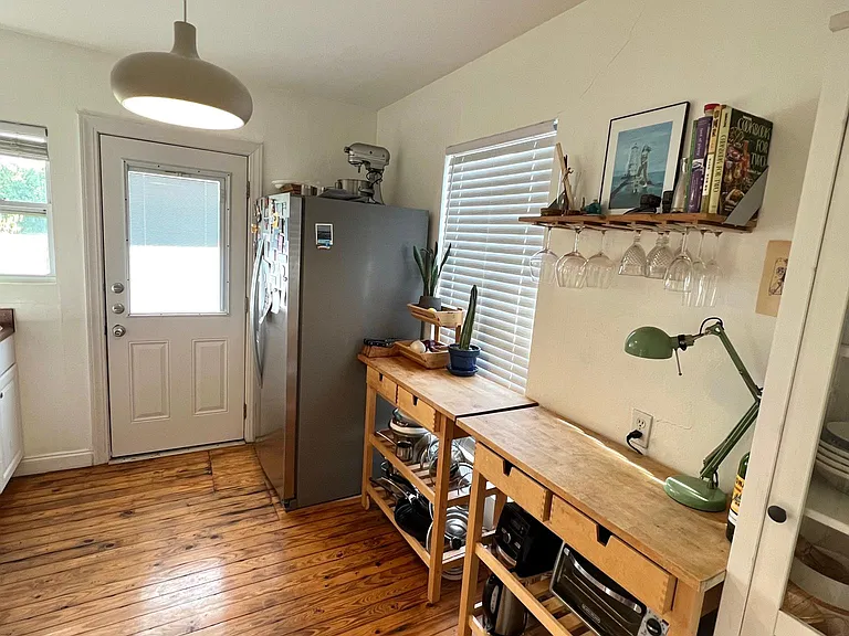 Kitchen with floor to ceiling window and exit to backyard.