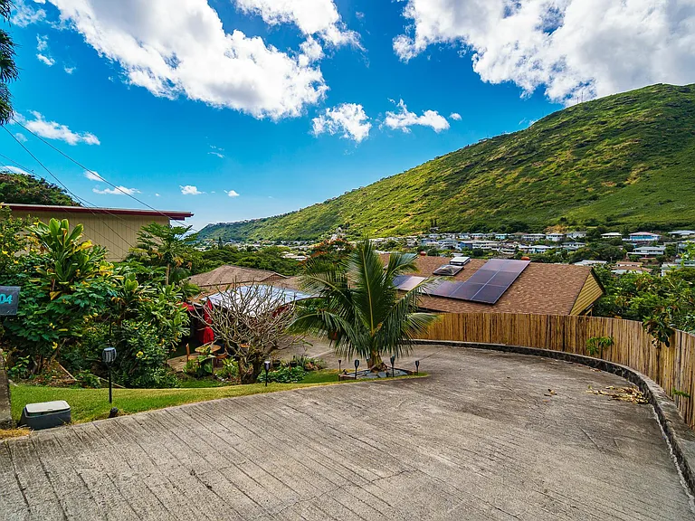 secluded cul de sac; bamboo fence along driveway leading to carport; driveway sloped and curved