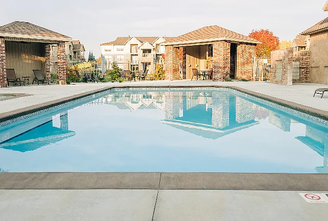 Pool in front of 2 pool cabanas and seating area