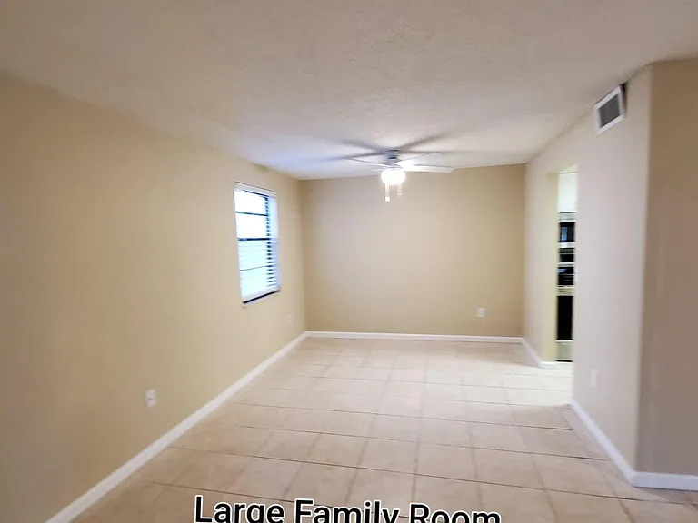 Large dining room with new ceiling fan and access to the family room and kitchen. New faux wood mini blind.