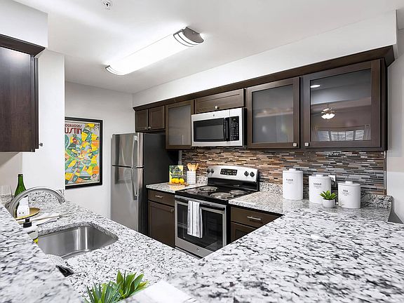 Kitchen with Granite Countertops, Stainless Appliances, and Bar Seating Area