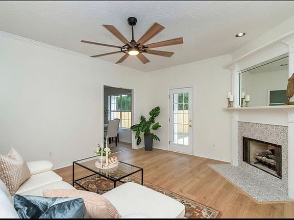 Living room with ornamental molding, hardwood / wood-style flooring, and ceiling fan