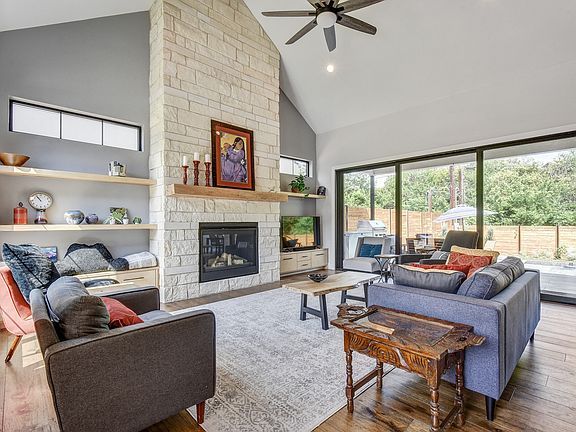 Entrance view of Living Area shows massive limestone mantel and gas fireplace, 8' sliding glass doors exit to covered patio and pool.