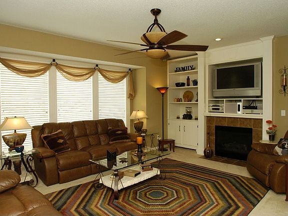 Great rm w/ upgraded ceiling fan, built-ins, fp, cust window trmts, & lg wind