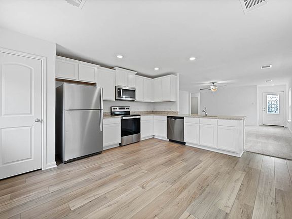 The kitchen comes with white cabinets and granite countertops!