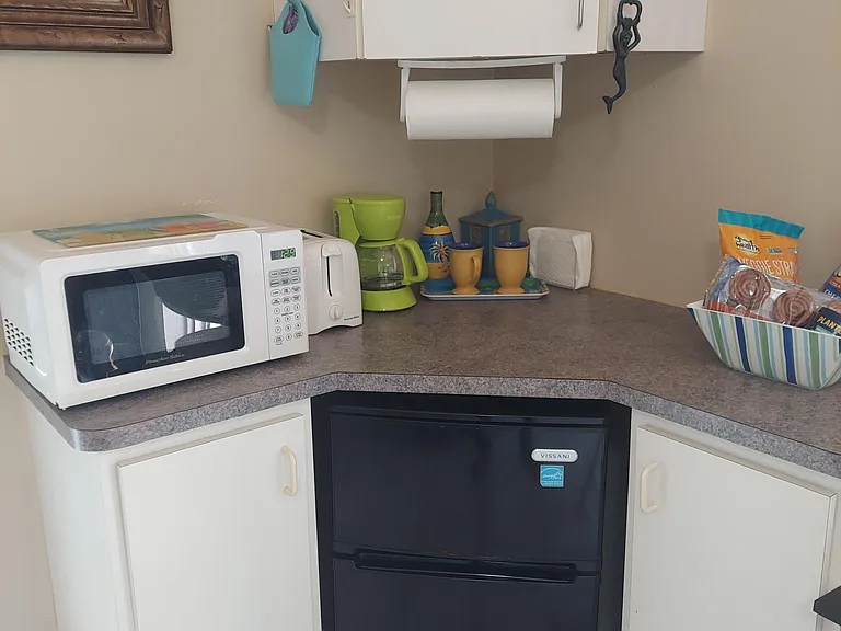 Kitchenette area includes small refrigerator, microwave, toaster, coffee maker,& other small appliances.