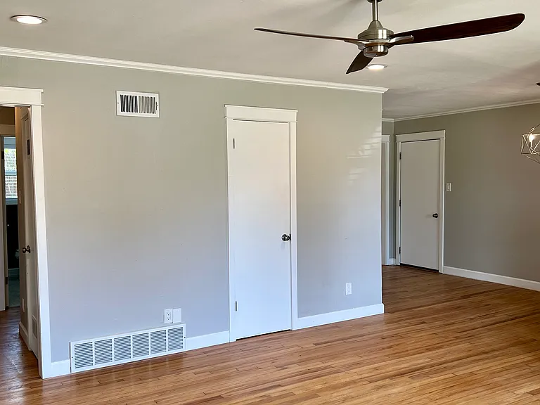 Living room looking towards dining room and hallway.
Coat closet door in the middle; garage door at the back.