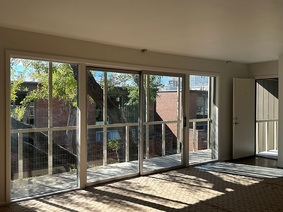 Living space looking to the balcony and courtyard, and the front door.