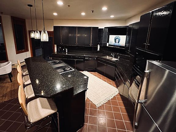 Large and fully stocked kitchen is ready for even the largest groups. Dining table plus bar seats up to 10 people