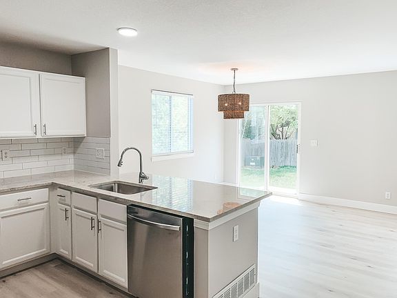 Fully renovated Kitchen including bar seating, granite counters, stainless steel appliances, renovated cabinets, tile backsplash, faucet and sink.