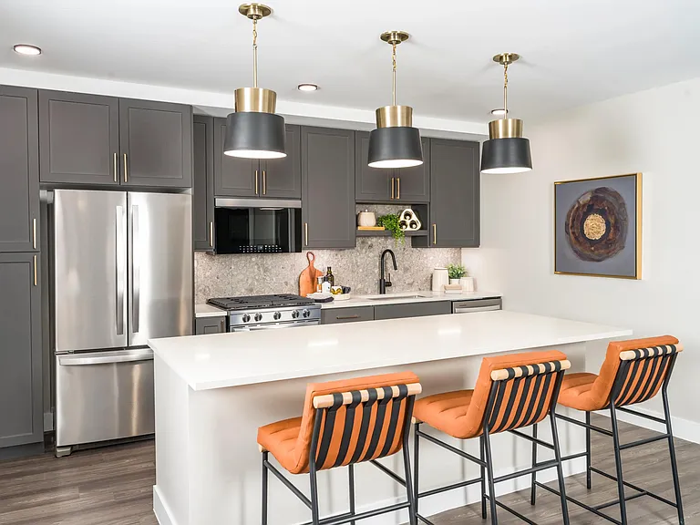 Modern kitchens feature sleek cabinetry, quartz countertops, and stainless steel appliances with designer pendant lighting.