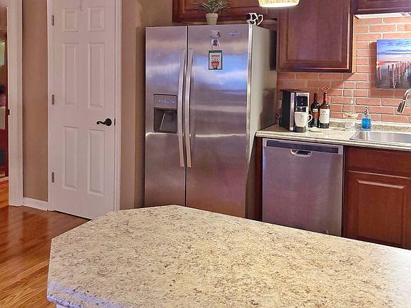 Laundry is in the closet right of the refrigerator with primary bedroom just beyond