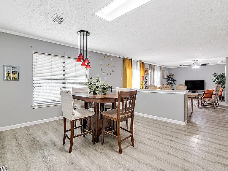 Open dining area with a breakfast-height table, pendant lighting, and easy flow into the adjacent living space.