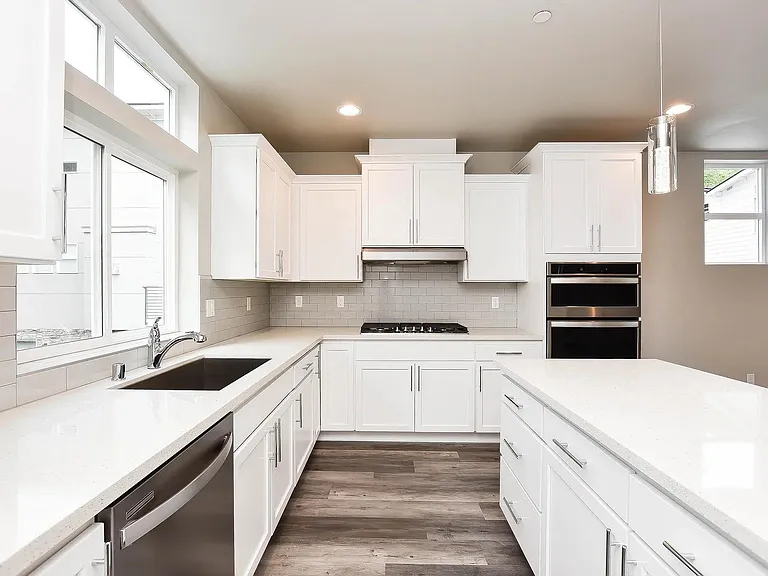 Large kitchen with Quartz countertops, gas cooktop, large sink, dishwasher, microwave oven and traditional oven.