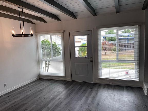 Spacious living and dining area with gorgeous lighting and wood beam ceilings