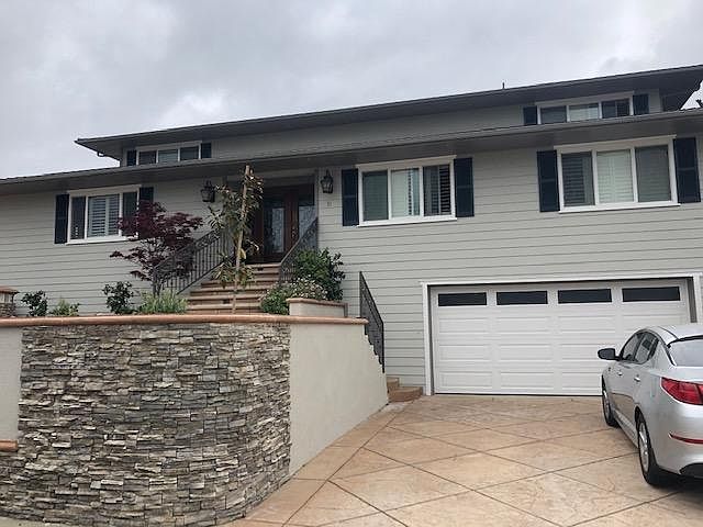 Front of house. One driveway on right, leading to garage.