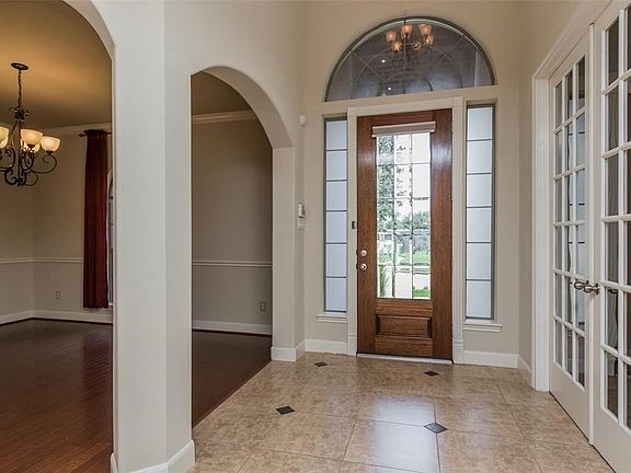 The entry of the home has large ceramic tile with decorative tile inserts with the formal dining, the  left and the spacious study to the right with glass French doors.