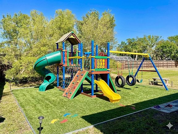 Backyard. The kids' playset is not there. Instead, there is a full backyard of grass
