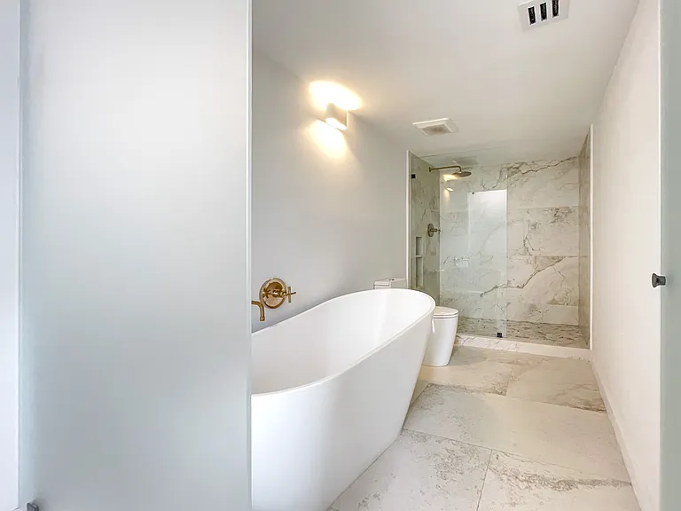 completely redesigned spa like primary bathroom with focus on natural light, neutral materials, space and comfort.