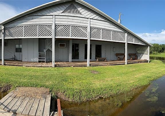 A panoramic view showing the back covered porch overlooking the lake, imagine all the fish fries and good times to be made!