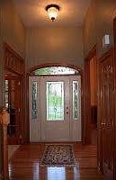 3/4 view decorative glass front door with matching side lights and transom