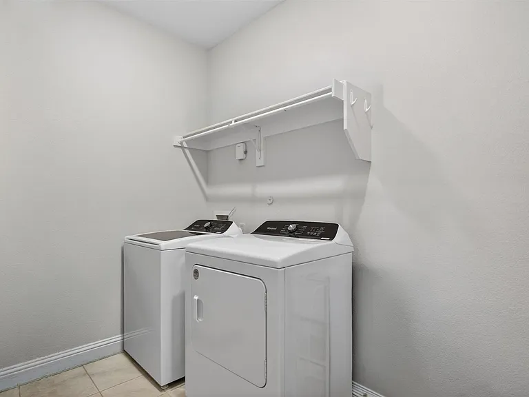 Dedicated laundry area featuring a white top-load washing machine and front-load dryer