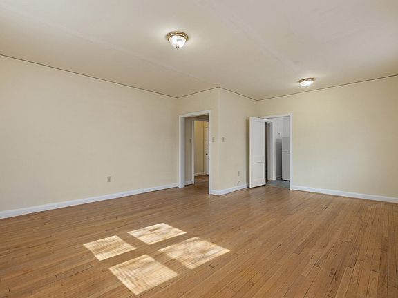 Bedroom with hardwood floor and bright windows