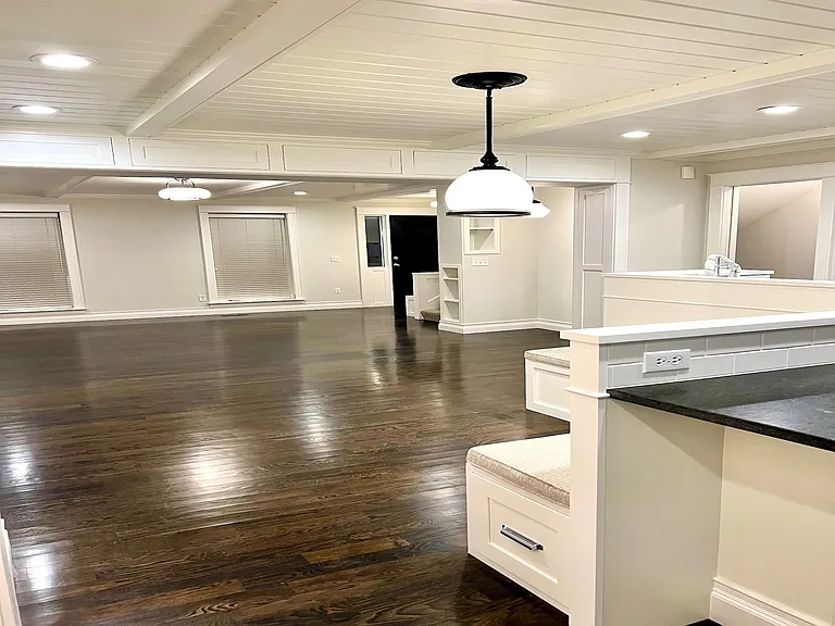 Main level great room that boasts an open, airy, coastal feeling design. From flooring to countertops to white beamed, beadboard ceilings