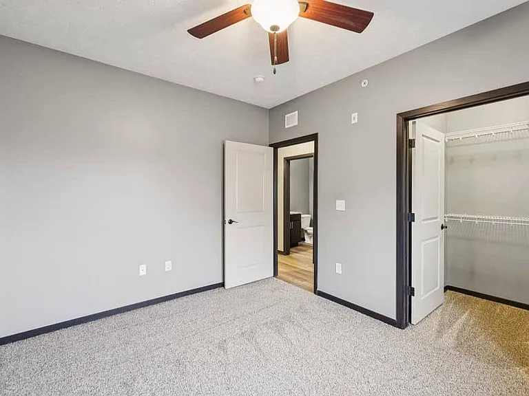 Get cozy in this carpeted bedroom with a walk-in closet and ceiling fan for year-round comfort and convenience.