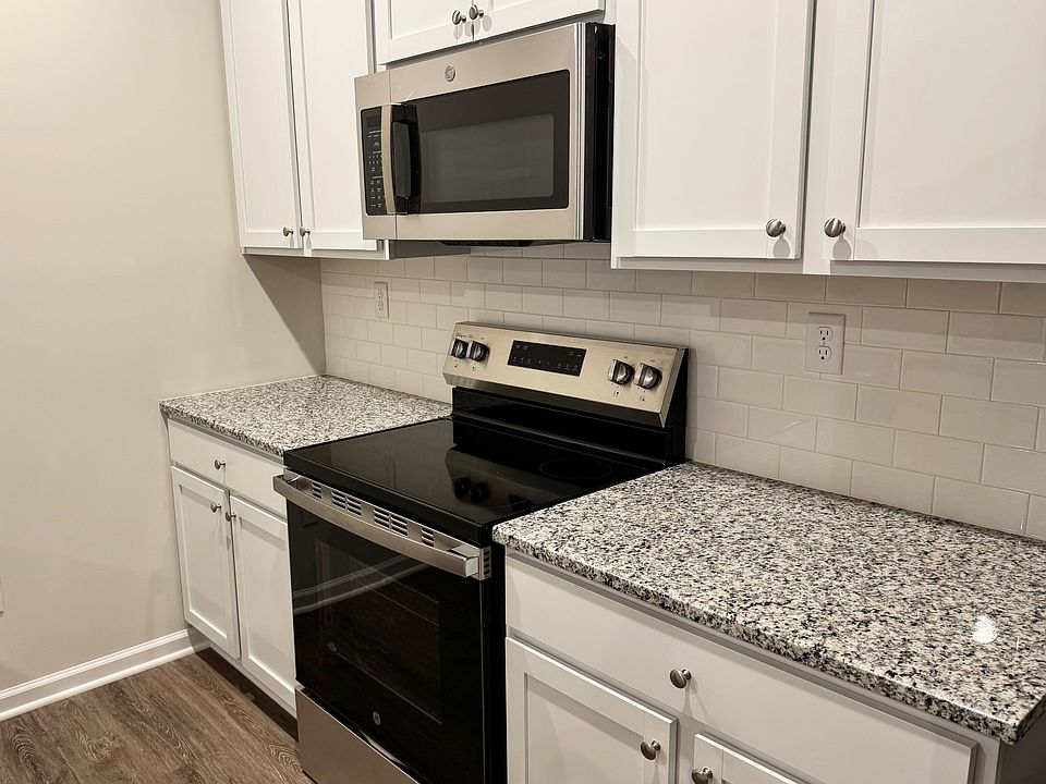 Modern kitchen with stainless steel appliances, granite countertops, and abundant cabinet space.
