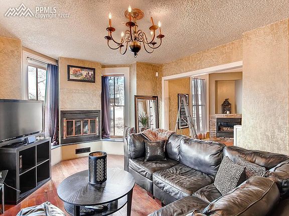 Large living room with fireplace, wood floors...