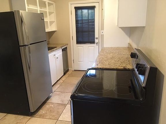 Stainless steel appliances and marble counter tops in kitchen.