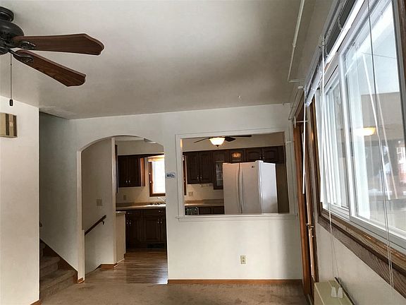 East view. Rt HALF of living rm looking into kitchen. Stairs up to bdms.