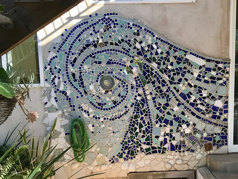 The back garden has a mosaic outdoor hot shower, perfect for after the beach!