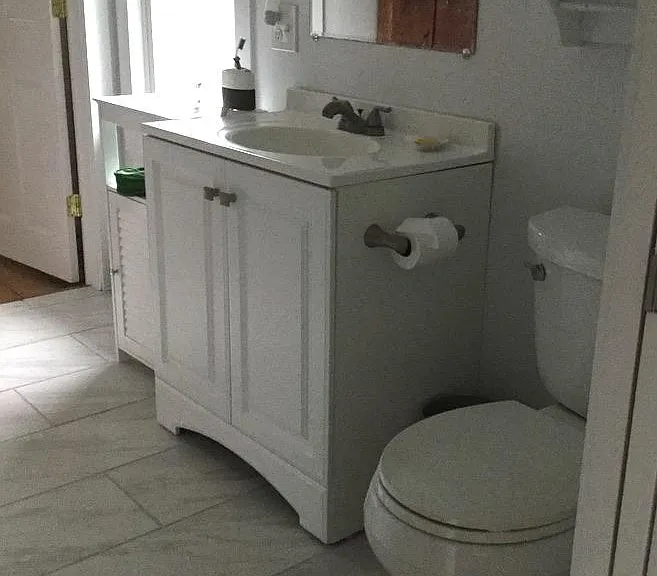 Upstairs bathroom has medicine cabinet, storage, tub/shower, marble floor