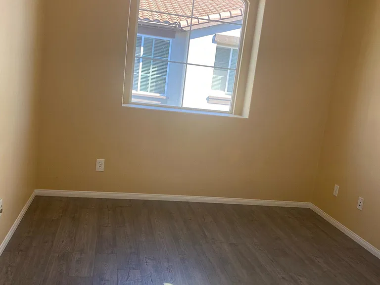 Secondary bedroom with new floors and window.