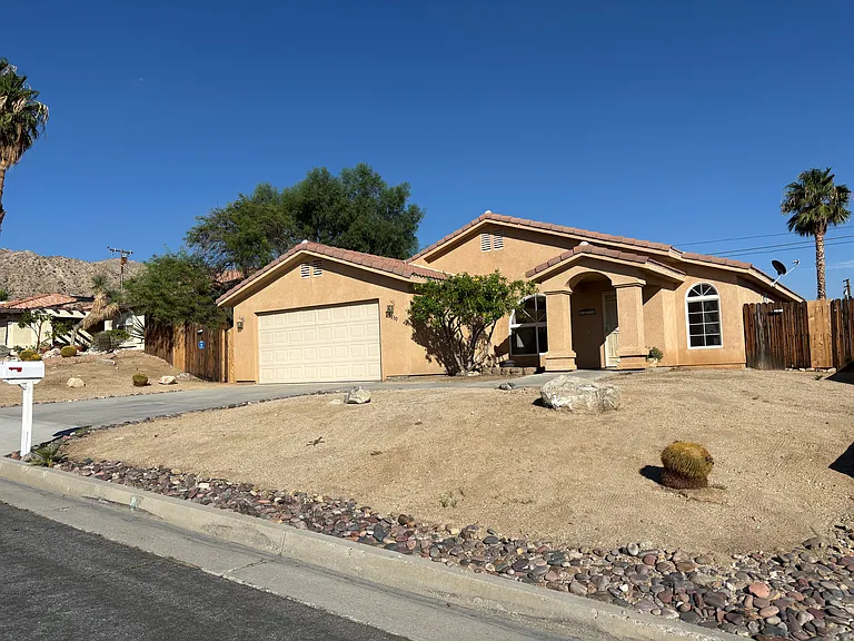 Single-story home with attached 2-car garage, low-maintenance desert landscaping, and a welcoming covered entry.