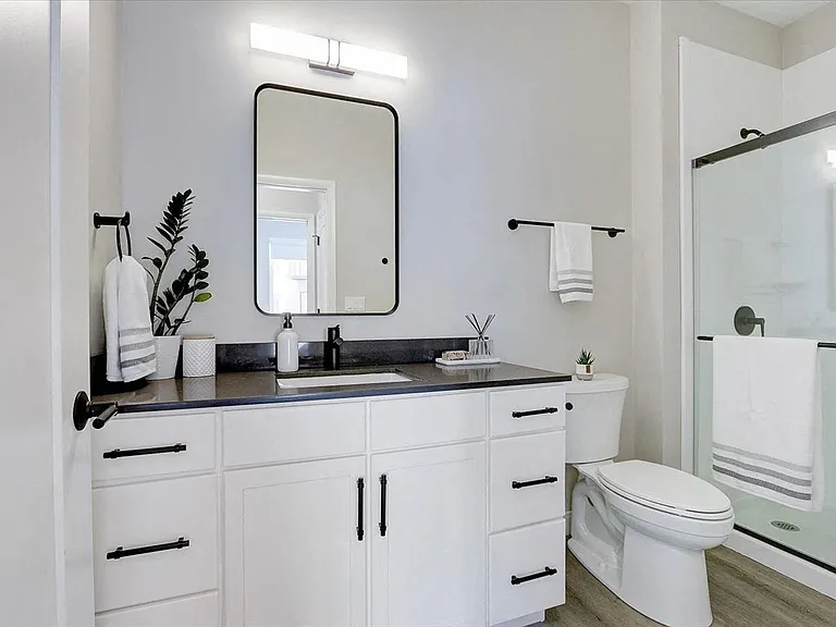 Spacious bathroom with quartz countertops and walk-in shower