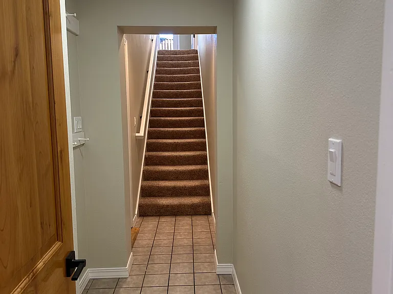 Hallway/stairs up, garage entry at left