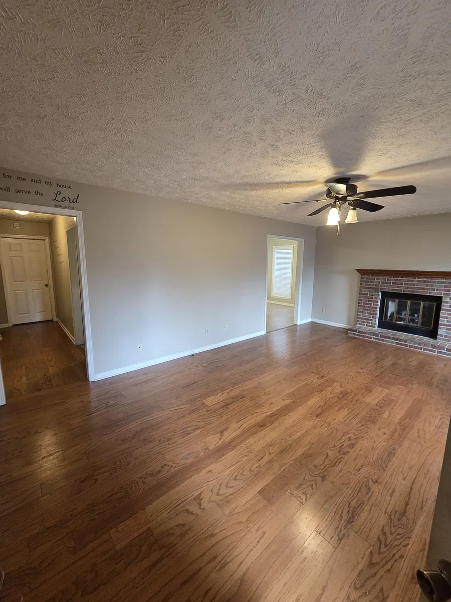 Living room with fireplace and ceiling fan - 118 Candlewick Dr