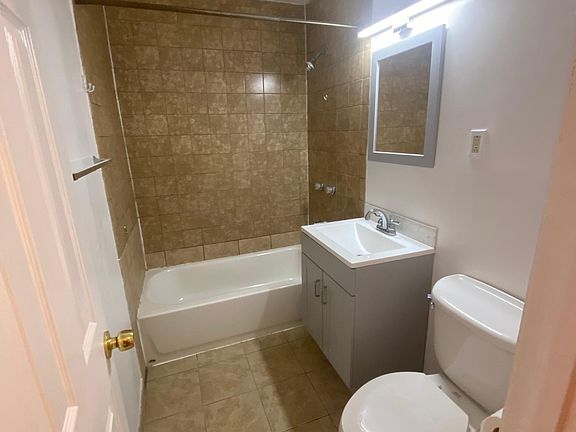 Spacious bathroom with brand new sink vanity, mirror, and light.
