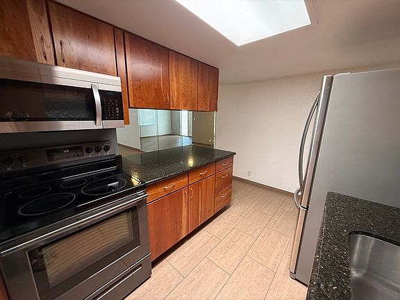 Kitchen with stainless steel appliances, and bar