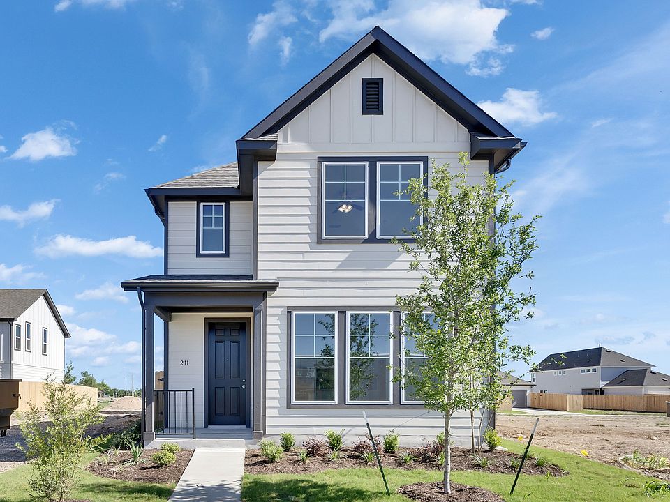 Elegant dark trim and fresh landscaping define this modern residence at Trinity at Spring Creek.
