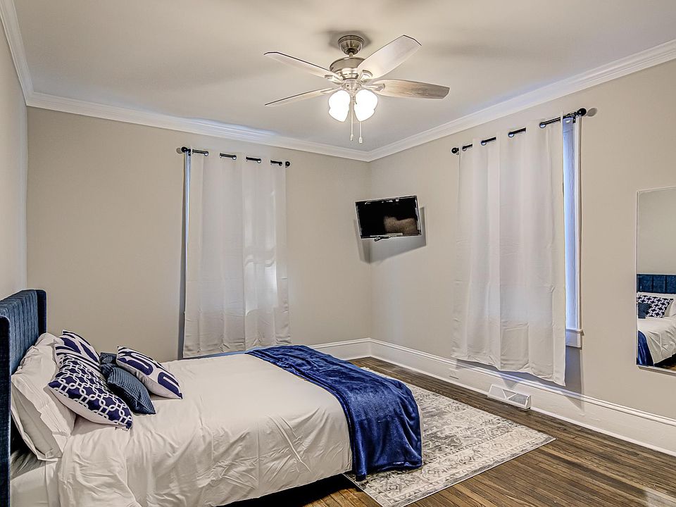 Fully furnished room with full length mirror, smart television, bed and memory foam mattress
