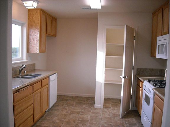 Kitchen with pantry, stove, microwave, stainless sink